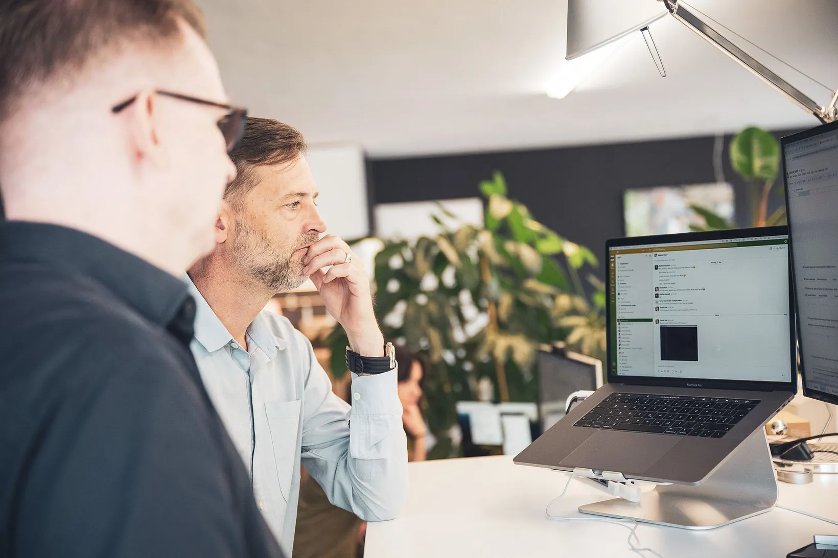 Zwei RTP-Mitarbeitende besprechen etwas an einem Laptop im Büro