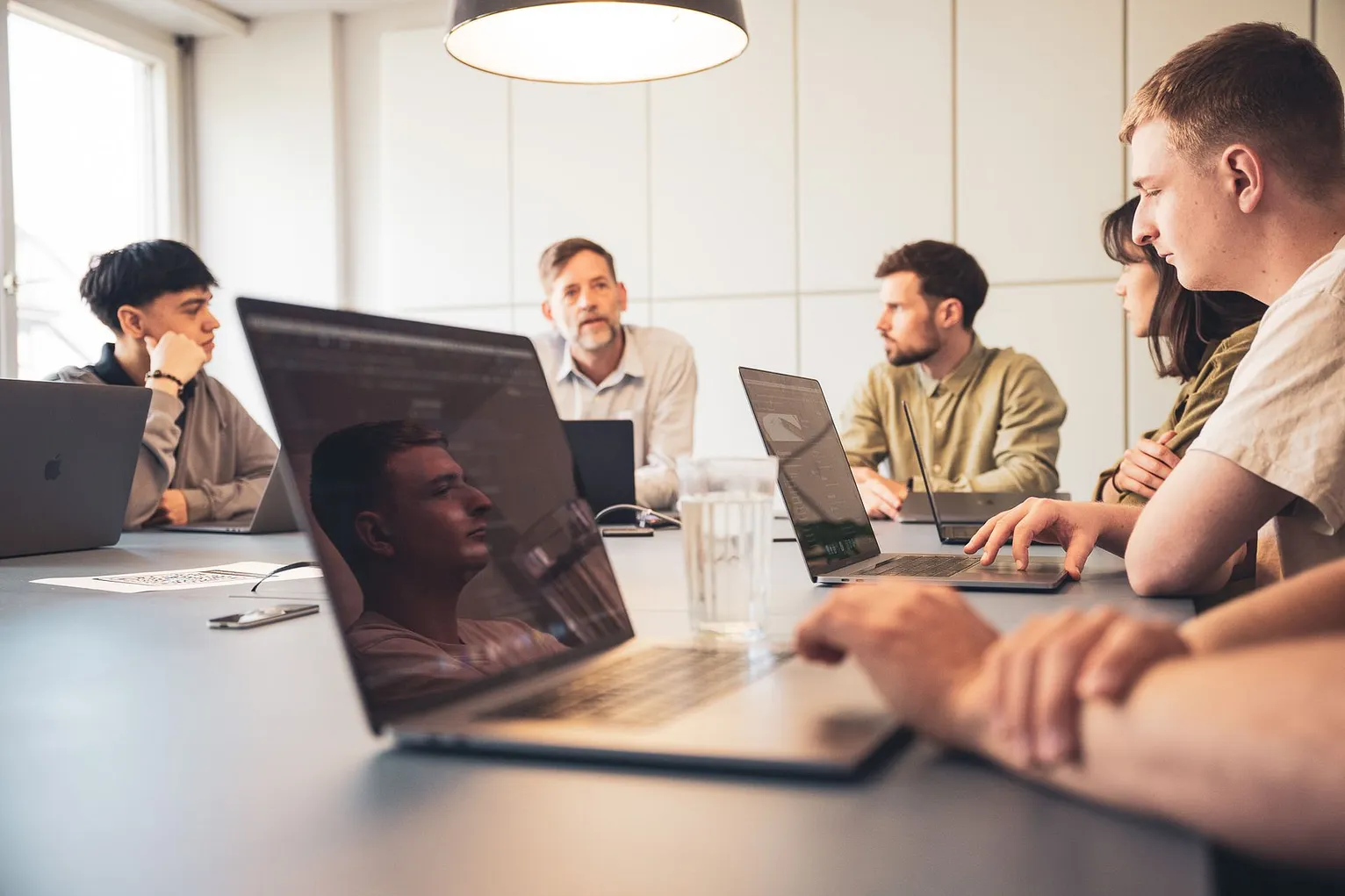 RTP-Team bei einer Besprechung am Sitzungstisch mit Laptops