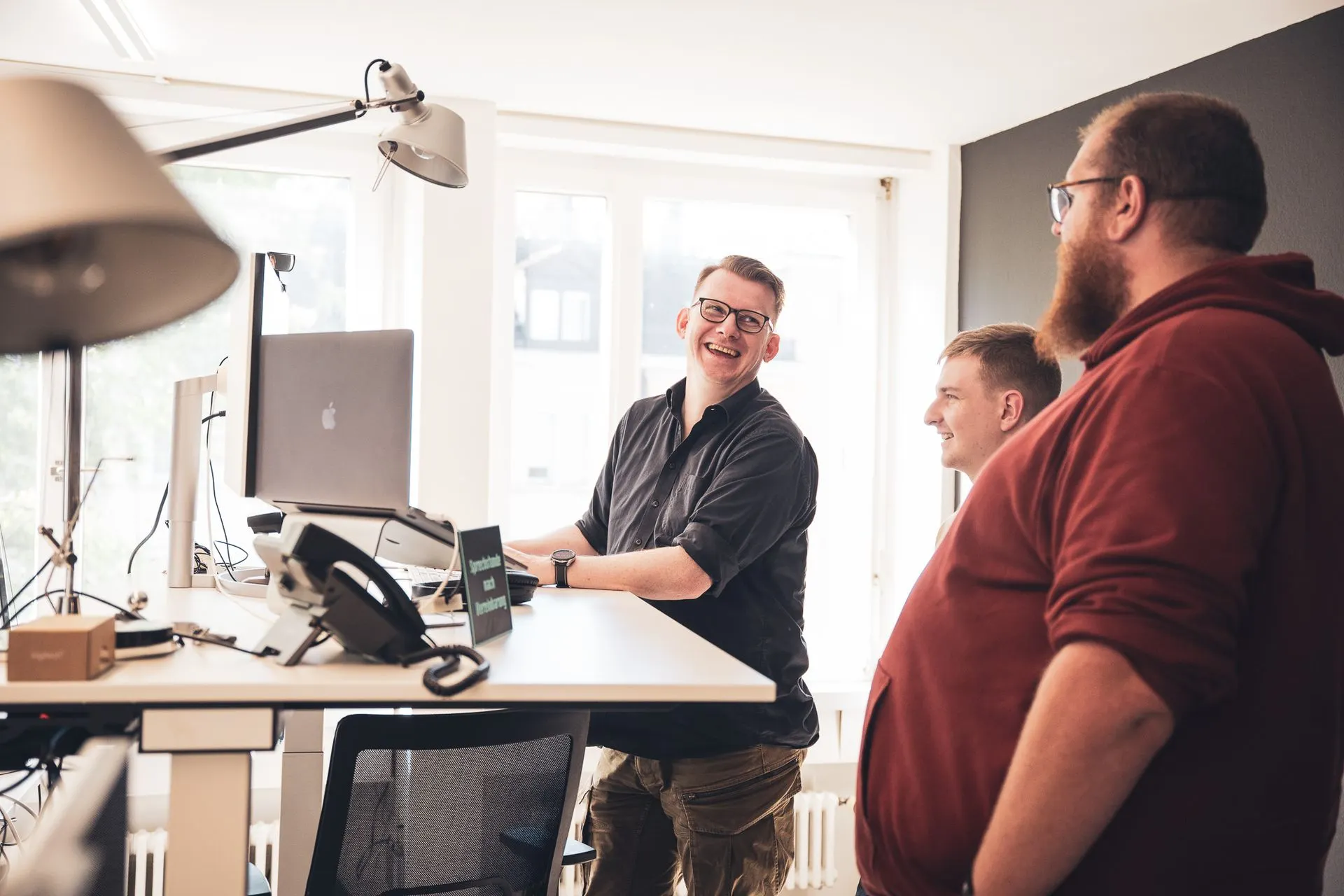 RTP-Team im Gespräch an einem Stehpult im Büro