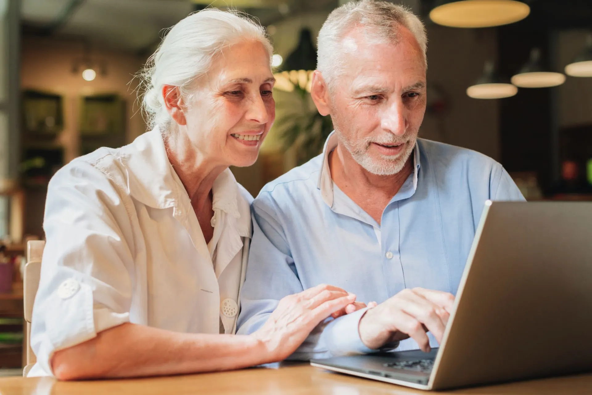 Ein Mann und eine Frau schauen gemeinsam auf einen Laptop.